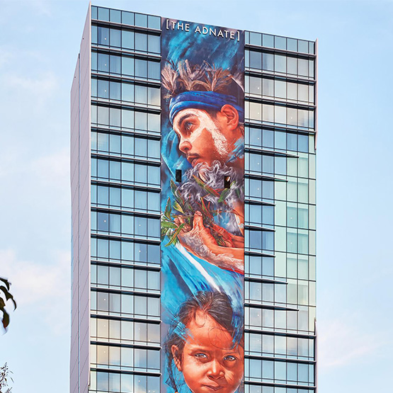 A tall building with a strip of colourful art along one wall